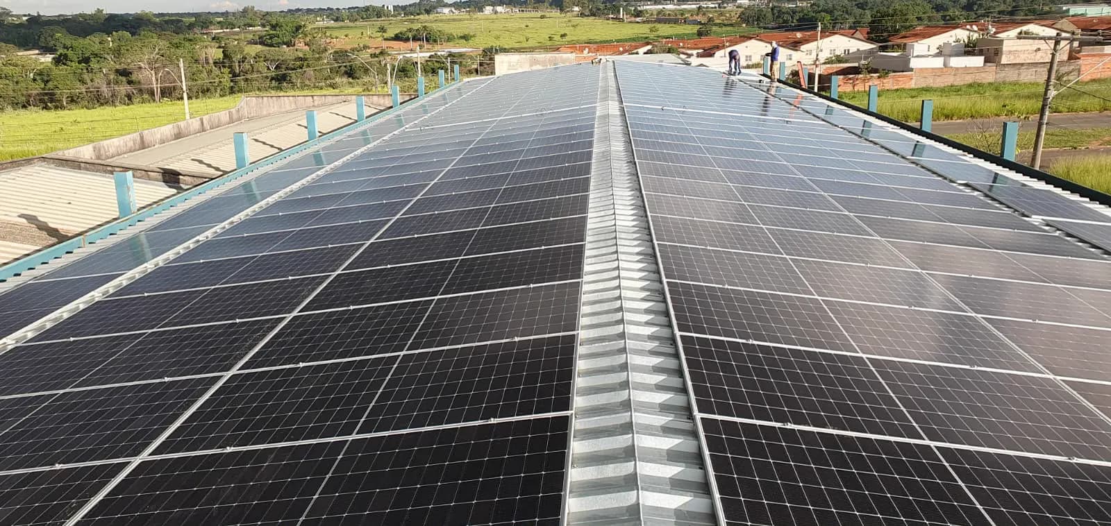 Usina solar comercial com centenas de placas em telhado metálico